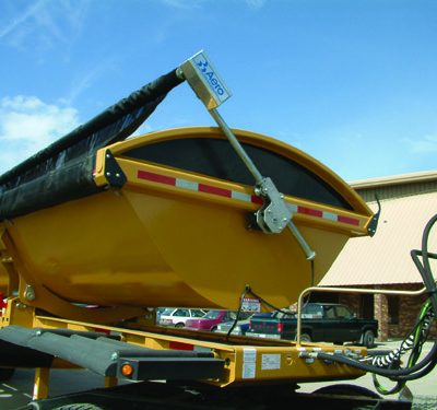 Aero Side Kick 2, side dump tarp system, front swing arm assembly on a yellow side dump trailer.